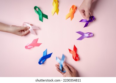 Hands of people holding colorful ribbons on pink background, cancer awareness, World cancer day, National cancer survivor day, world autism, supported living and illness, Prostate awareness concept. - Powered by Shutterstock