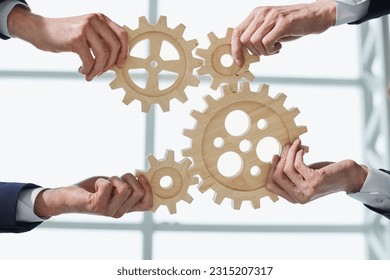 Hands of people office workers business partners making common picture of wooden gears on table, selective focus - Shutterstock ID 2315207317