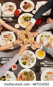 Hands Of People Toasting At Dinner, View From Above