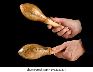 hands of percussionist playing cuban maracas on black background