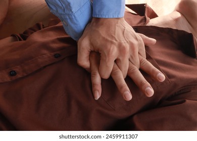 hands perform CPR. CPR is first aid for someone who stops breathing or has no heartbeat. Hands press chest and give breaths. It saves lives. - Powered by Shutterstock