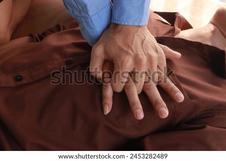 hands perform CPR. CPR is first aid for someone who stops breathing or has no heartbeat. Hands press chest and give breaths. It saves lives.