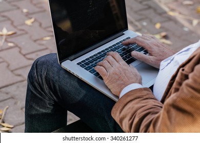 Hands Of A Person Using A Laptop From Back