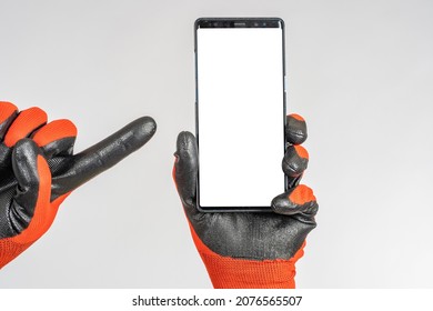 Hands phone. Hands in work gloves as metaphor for builders. Builder points to display. Place for building app. Website for finding foreman. Copy space on cellphone screen. Apps building company