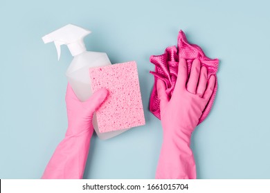Hands in pink gloves hold detergents. Cleaning or housekeeping concept background. Copy space. Flat lay, Top view.