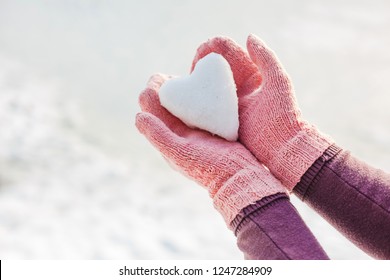 Hands In Pink Gloves Holding Snow Heart. Winter Time