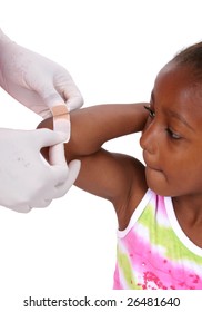 Hands Placing Bandaid On Child's Arm.