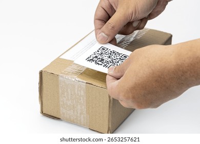 A hands placing dummy qr code label on cardboard shipping box, symbolizing modern logistics and efficient package tracking. scene highlights integration of technology in shipping processes