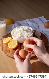 hands placing eggs on the table next to a bowl of cottage cheese	