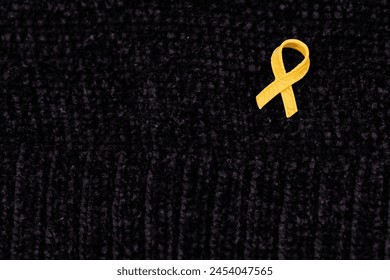 Hands placing a yellow ribbon pin on fabric, the international symbol of advocating for the return of hostages and raising awareness for cancer (specifically sarcoma) support and solidarity. - Powered by Shutterstock