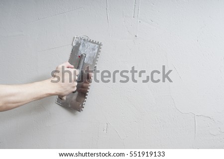 Hands Plasterer at work. Application of the plaster on the wall. textured plaster