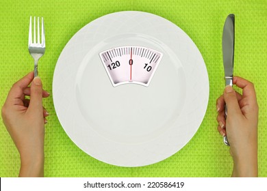 Hands and plate with weighing scale on the table