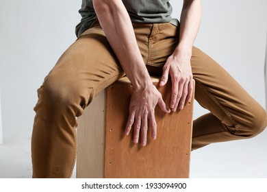 Hands playing cajon on a white background.