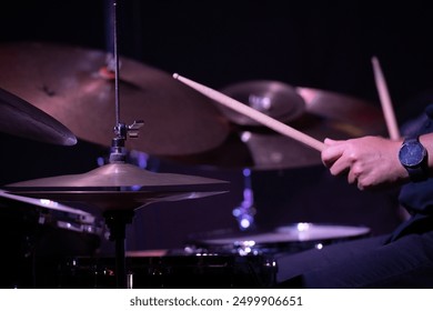 Hands playing the drums in a jazz performance, highlighting the rhythm and movement with a focus on the drumsticks. - Powered by Shutterstock