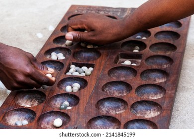 Hands playing Mancala game, Stone town, Tanzania. Mancala is a game which is very popular in Africa and Arabs - Shutterstock ID 2141845199