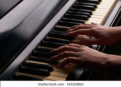 Hands Playing On An Old Black Piano