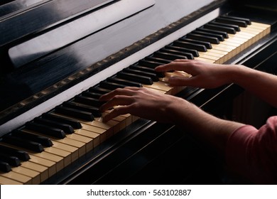 Hands Playing On An Old Black Piano