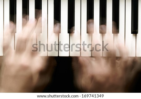 Hands playing piano. Motion blur