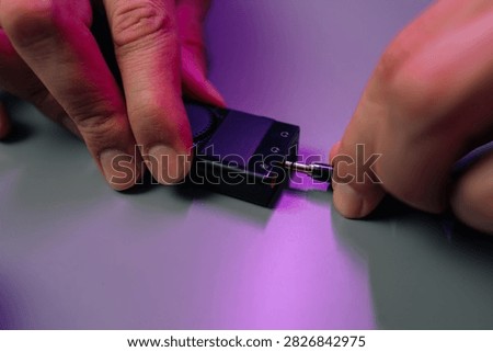 Hands plugging an audio jack into portable digital music player for connecting to other audio equipment, concept of technology, entertainmentsound.