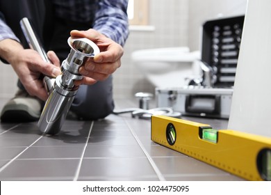 hands plumber at work in a bathroom, plumbing repair service, assemble and install concept