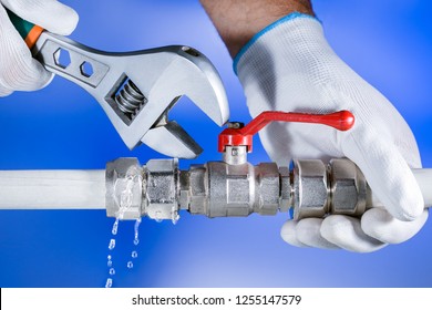 Hands Plumber At Work In A Bathroom, Plumbing Repair Service. Leak Of Water. Repair Plumbing.