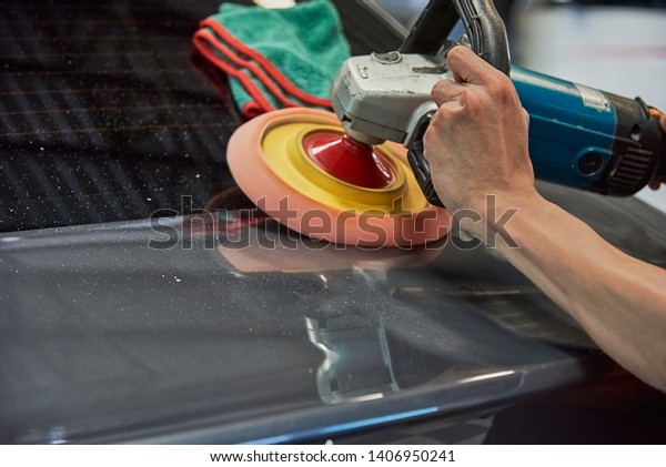 Hands Polishing Car With Rotary\
Car Polisher. Polishing On Car Paint Surface. Foam Pad In Blur\
Motion From Vibration Of Polisher Machine. Selected\
Focus