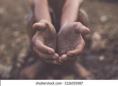hands poor child or beggar begging you for help sitting at dirty slum. concept for poverty or hunger people,human Rights,donate and charity,background text