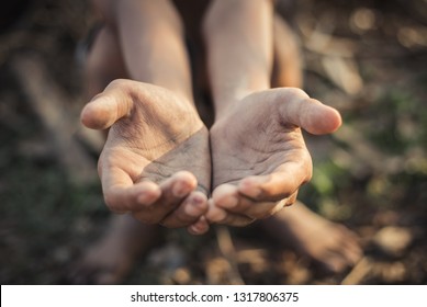 hands poor child or beggar begging you for help sitting at dirty slum. concept for poverty or hunger people,human rights,donate and charity for 
underprivileged children in third world 
