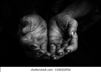 hands poor old man or beggar begging you for help sitting at dirty slum. concept for poverty or hunger people,human Rights,donate and charity,background text.black and white tone