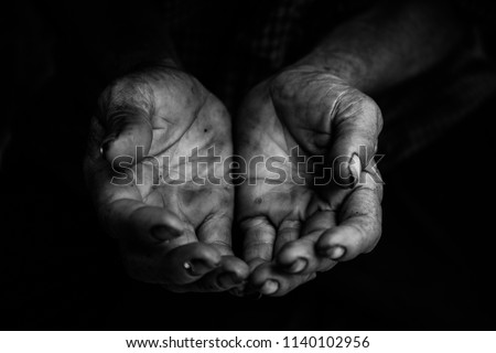 hands poor old man or beggar begging you for help sitting at dirty slum. concept for poverty or hunger people,human Rights,donate and charity,background text.black and white tone