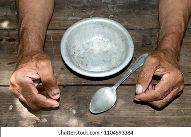 hands the poor old man's and empty bowl on wood background. The concept of hunger or poverty. Selective focus. Poverty in retirement.Homeless.  Alms