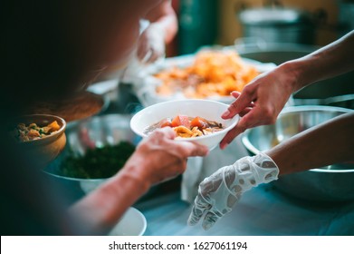 The hands of the poor are waiting to receive food from the rich, compassionate, free food donations to the homeless - Shutterstock ID 1627061194