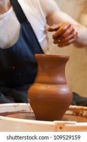 hands of a potter, creating an earthen jar on the circle