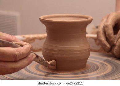 Hands of a potter, creating an earthen jar on pottery wheel. - Shutterstock ID 662472211