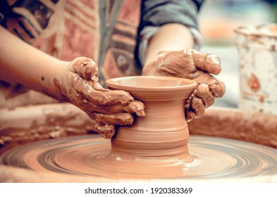 Hands of a potter at work. Potter making ceramic mug on the pottery wheel - Powered by Shutterstock