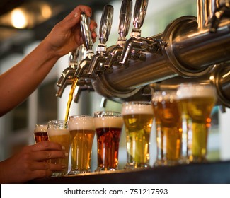 Hands Pouring A Flight Of Beer Samples