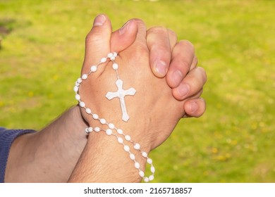 Hands in prayer. Prayer to God. Spiritual development. Christian cross for prayer