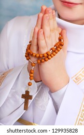 Hands Of Praying Boy Going To The First Holy Communion With A Wooden Rosary