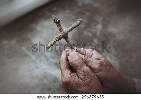 Hands praying with cross