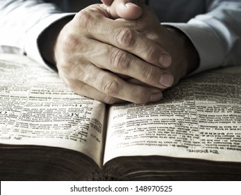 Hands Praying On Bible