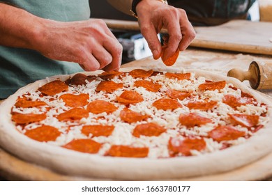 Hands Preparing A Pizza Or Making A Homemade Pepperoni Pizza