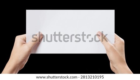 Hands presenting empty horizontal paper mockup, isolated on black background