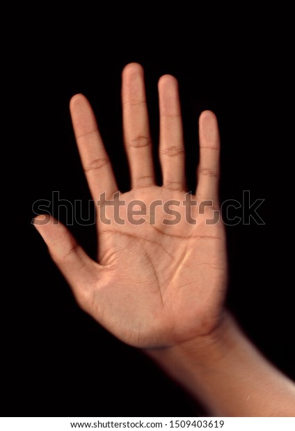 hands pressed against the glass with a black background.