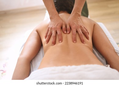 Hands pressing back of woman in massage center in close up shot and from above - Shutterstock ID 2238946191