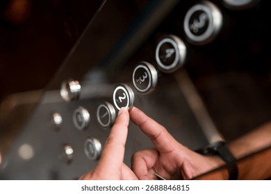 Hands and pressing button in elevator for transportation in building. Elevator control panel in small building