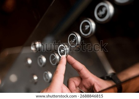 Hands and pressing button in elevator for transportation in building. Elevator control panel in small building