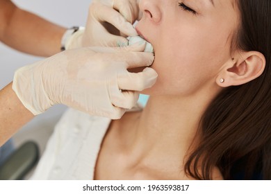 Hands pressing cast to upper jaw of female - Powered by Shutterstock