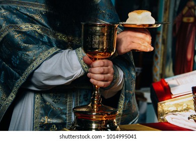 Hands Of Priest And Orthodox Prosphora For Communion During Holiday Prayers In Church