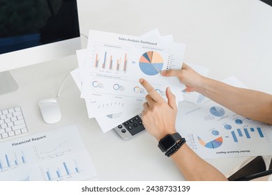 Hands of a professional examining a global market analysis report with various charts, graphs, and a world map for comprehensive business insights - Powered by Shutterstock