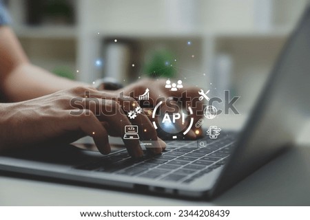 Hands of programmer and laptop with API or Application Program Interface, smart phone and online application concept.
